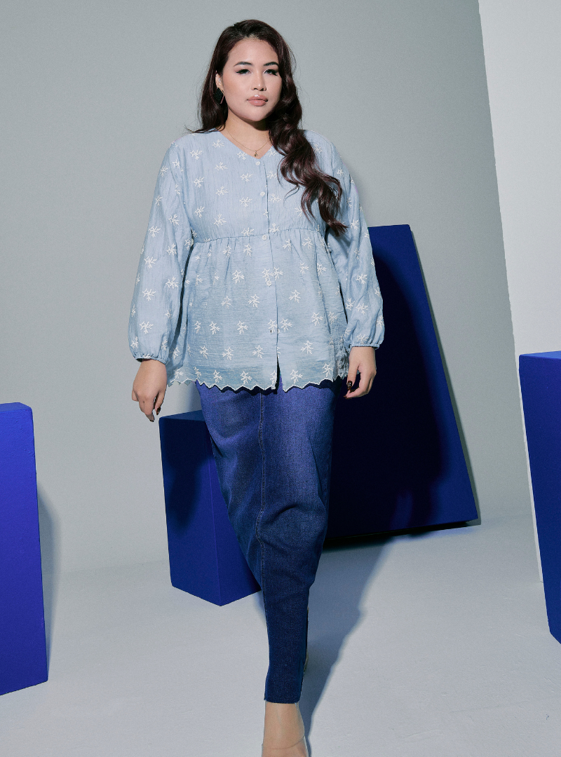 A woman dressed in Baby Blue Tun Ava Peplum Embroidered Top