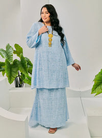 A woman dressed in Baby Blue Tun Bibah Textured Kurung