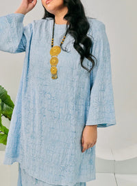 A woman dressed in Baby Blue Tun Bibah Textured Kurung