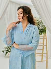 A woman dressed in Baby Blue Tun Farah Embroidered Eyelet Kurung
