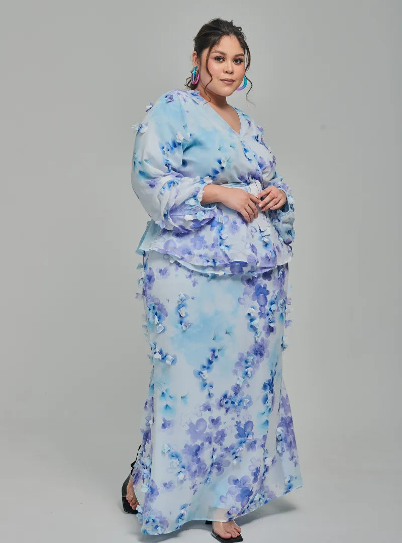 A woman dressed in Baby Blue Tun Hamidah Chiffon Wrap Kurung