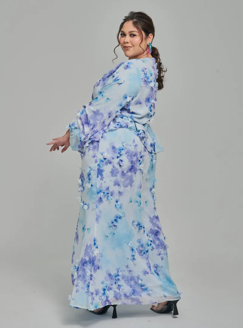 A woman dressed in Baby Blue Tun Hamidah Chiffon Wrap Kurung