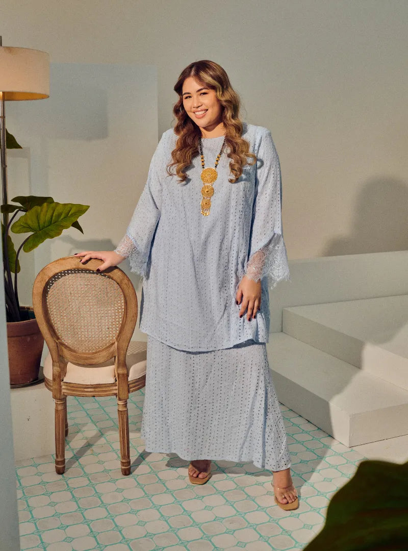 A woman dressed in Baby Blue Tun Inna Kurung