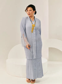 A woman dressed in Baby Blue Tun Jamilah Pleated Kurung