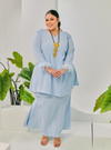 A woman dressed in Baby Blue Tun Malika Feather Wrap Kurung