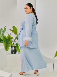 A woman dressed in Baby Blue Tun Malika Feather Wrap Kurung