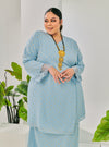 A woman dressed in Baby Blue Tun Tipah Dotted Wrap Kurung