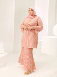 A woman dressed in Baby Salmon Tun Maryam Eyelet Kurung