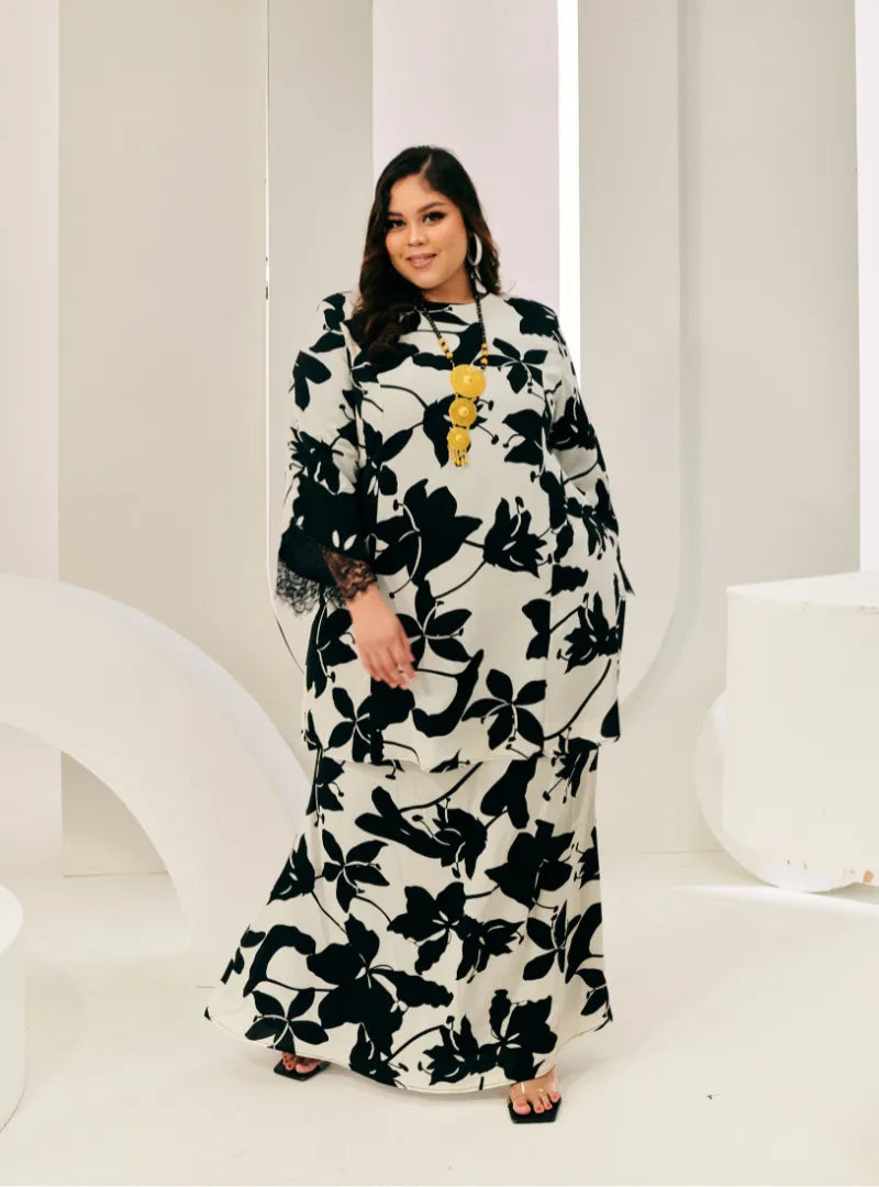 A woman dressed in Black Daun Tun Rokiah Printed Kurung Pahang