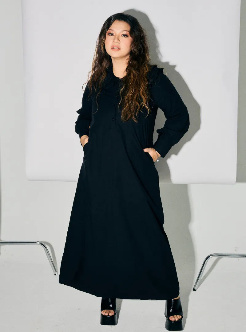 A woman dressed in Black Marsya Cotton Long Sleeve Dress