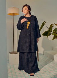 A woman dressed in Black Tun Bibah Textured Kurung