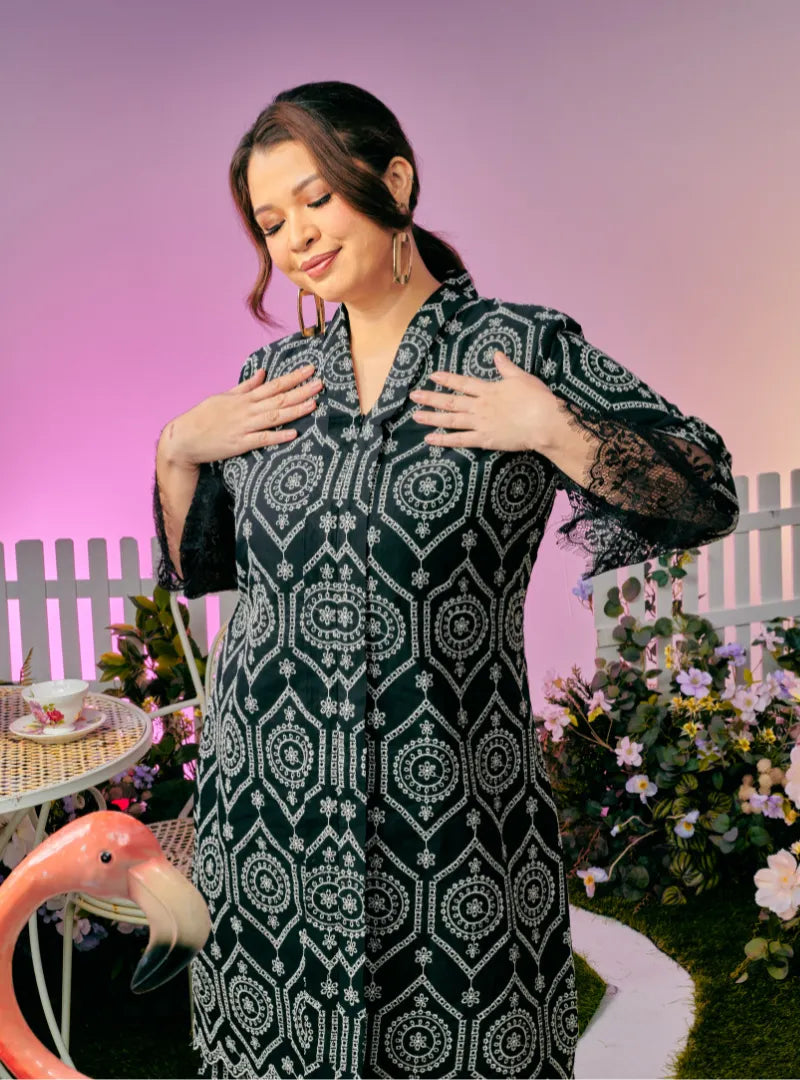 A woman dressed in Black Tun Farah Embroidered Eyelet Kurung