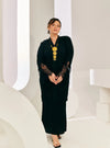 A woman dressed in Black Tun Jamilah Pleated Kurung