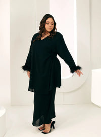 A woman dressed in Black Tun Malika Feather Wrap Kurung