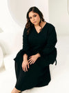 A woman dressed in Black Tun Malika Feather Wrap Kurung