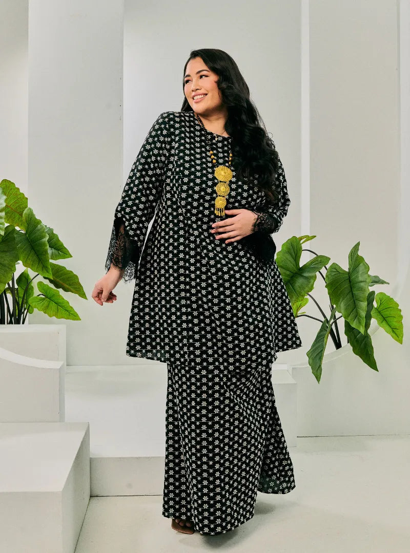 A woman dressed in Black Tun Maryam Eyelet Kurung