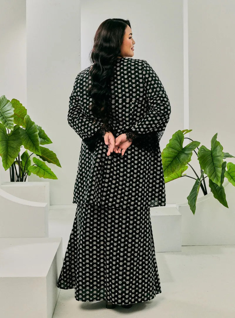 A woman dressed in Black Tun Maryam Eyelet Kurung