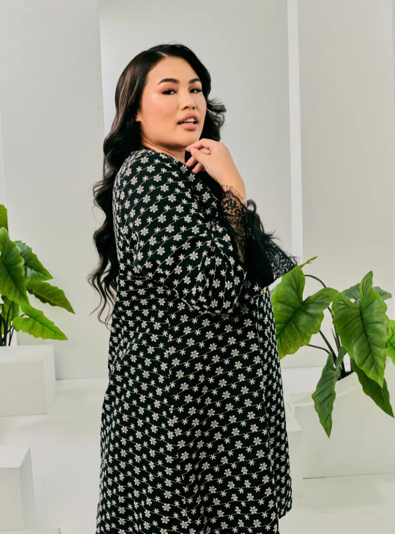 A woman dressed in Black Tun Maryam Eyelet Kurung