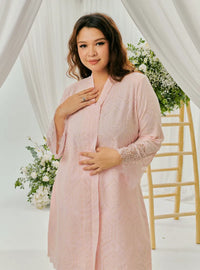 A woman dressed in Blush Pink Tun Farah Embroidered Eyelet Kurung