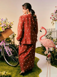 A woman dressed in Brick Orange Tun Anisah Kebaya Kurung