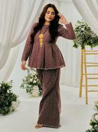 A woman dressed in Burgundy Tun Zera Eyelet Kurung