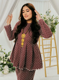 A woman dressed in Burgundy Tun Zera Eyelet Kurung