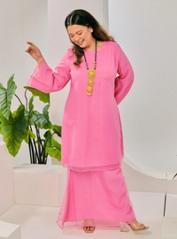 A woman dressed in Candy Pink Tun Sharimah Organza Kurung