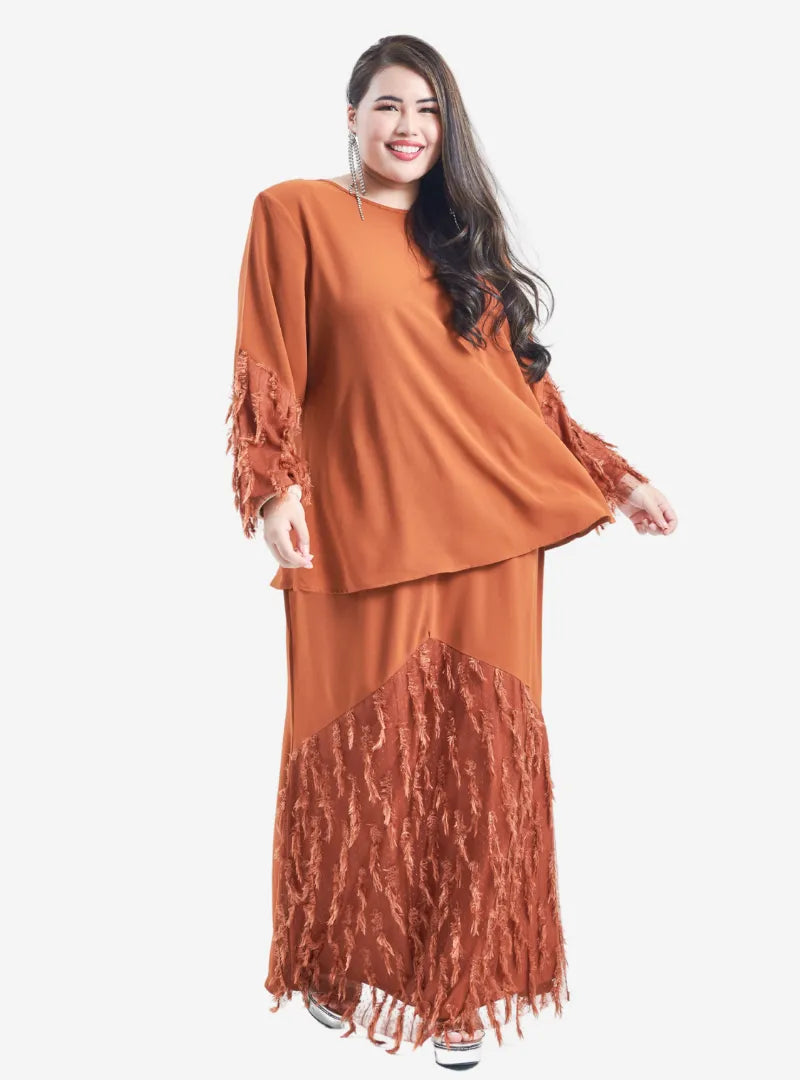 A woman dressed in Caramel Lalang Feather Kurung