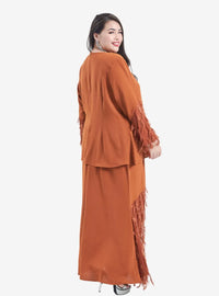 A woman dressed in Caramel Lalang Feather Kurung