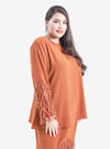 A woman dressed in Caramel Lalang Feather Kurung