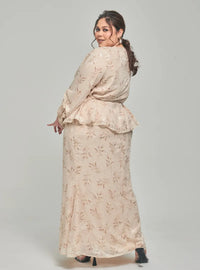 A woman dressed in Champagne Padi Tun Umaiyah Padi Chiffon Wrap Kurung