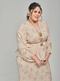 A woman dressed in Champagne Padi Tun Umaiyah Padi Chiffon Wrap Kurung