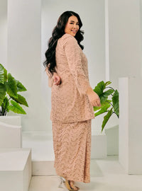 A woman dressed in Champagne Tun Huda Eyelet Kurung