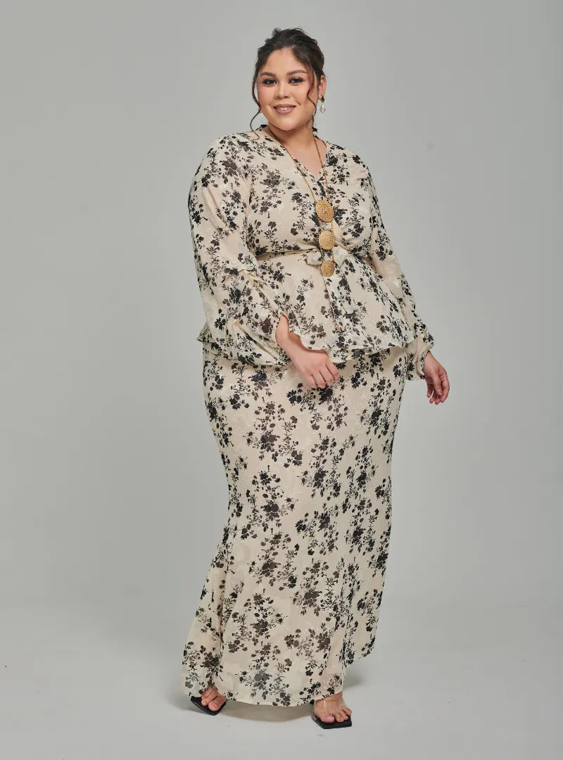 A woman dressed in Champagne Tun Sarah 3D Chiffon Wrap Kurung