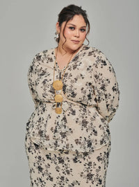 A woman dressed in Champagne Tun Sarah 3D Chiffon Wrap Kurung