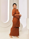 A woman dressed in Cinnamon Tun Jamilah Pleated Kurung