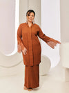 A woman dressed in Cinnamon Tun Jamilah Pleated Kurung