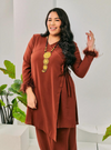 A woman dressed in Cinnamon Tun Malika Feather Wrap Kurung