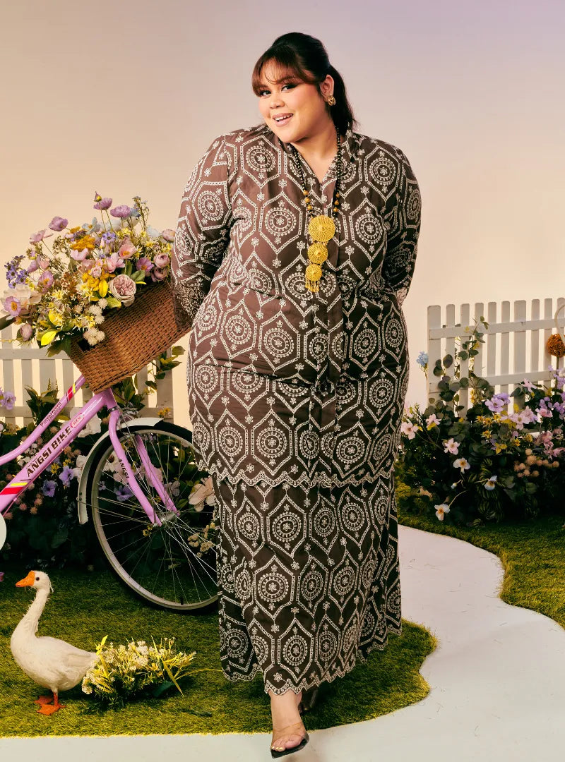 A woman dressed in Coco Tun Farah Embroidered Eyelet Kurung