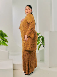 A woman dressed in Coffee Tun Huda Eyelet Kurung