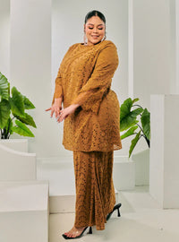 A woman dressed in Coffee Tun Huda Eyelet Kurung