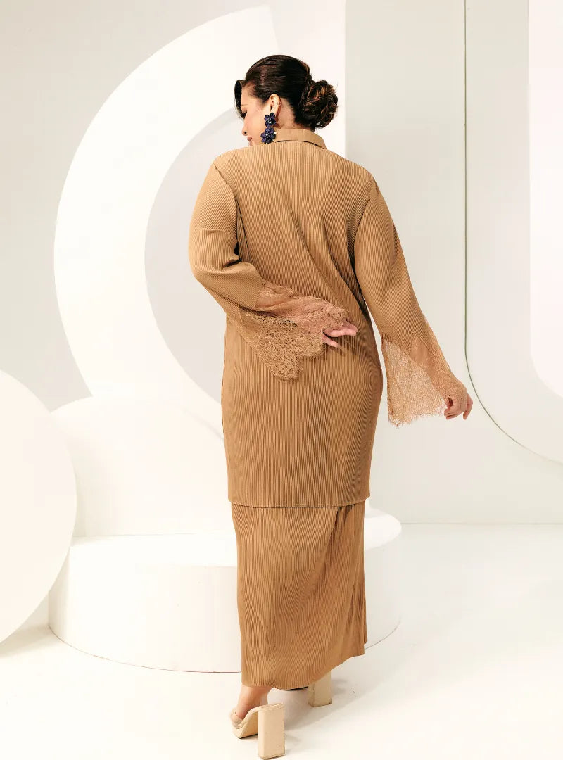 A woman dressed in Coffee Tun Jamilah Pleated Kurung