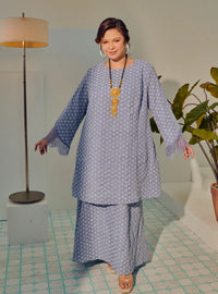 A woman dressed in Dusty Blue Tun Maryam Eyelet Kurung