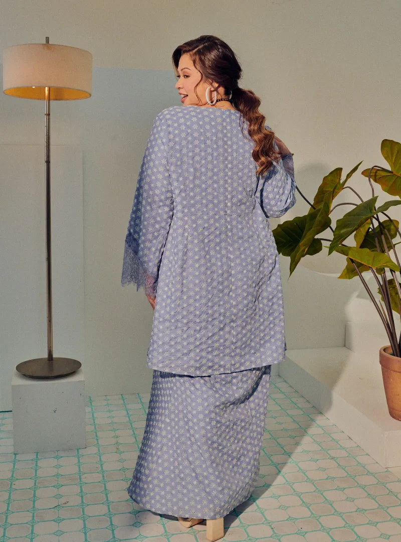 A woman dressed in Dusty Blue Tun Maryam Eyelet Kurung