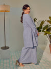 A woman dressed in Dusty Blue Tun Maryam Eyelet Kurung