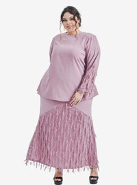 A woman dressed in Dusty Lilac Lalang Feather Kurung