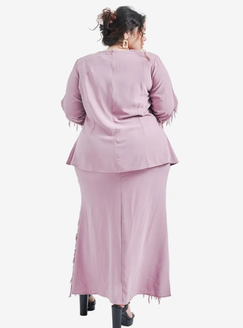 A woman dressed in Dusty Lilac Lalang Feather Kurung