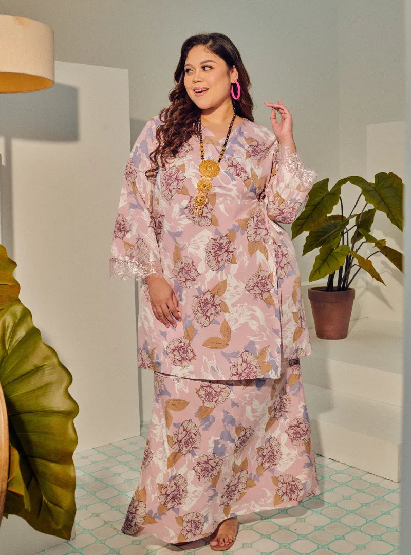 A woman dressed in Dusty Pink Tun Anum Printed Wrap Kurung