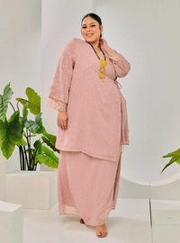 A woman dressed in Dusty Pink Tun Tipah Dotted Wrap Kurung