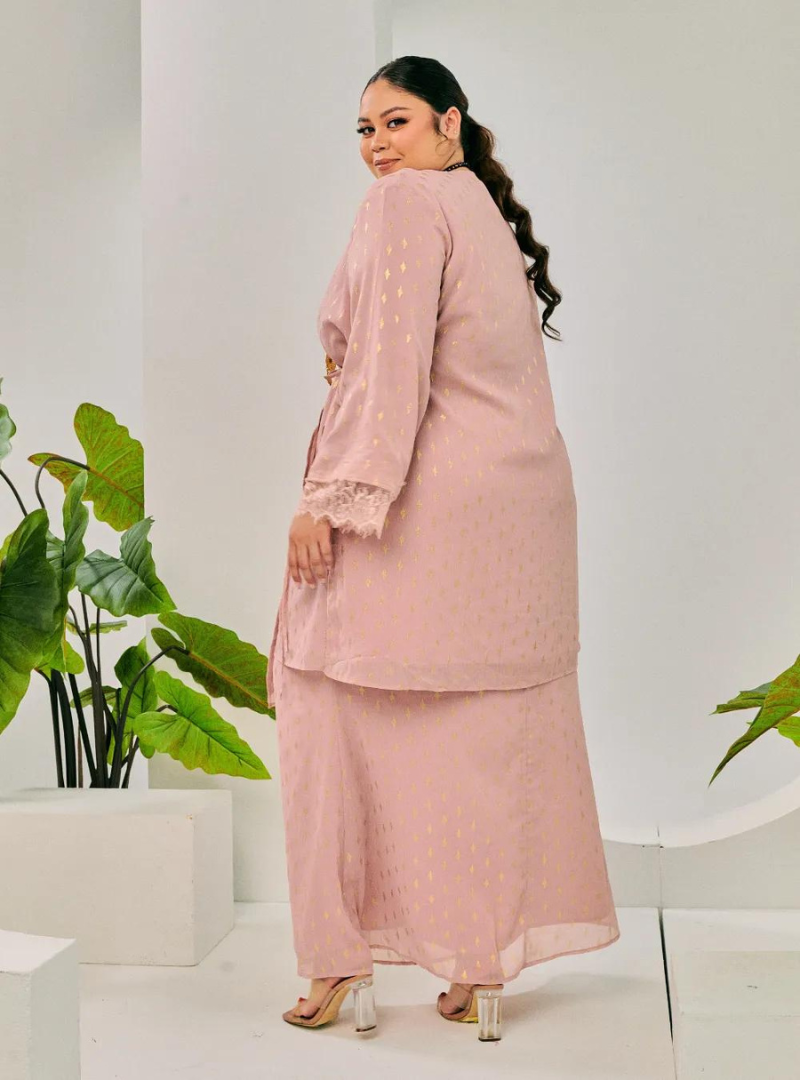 A woman dressed in Dusty Pink Tun Tipah Dotted Wrap Kurung